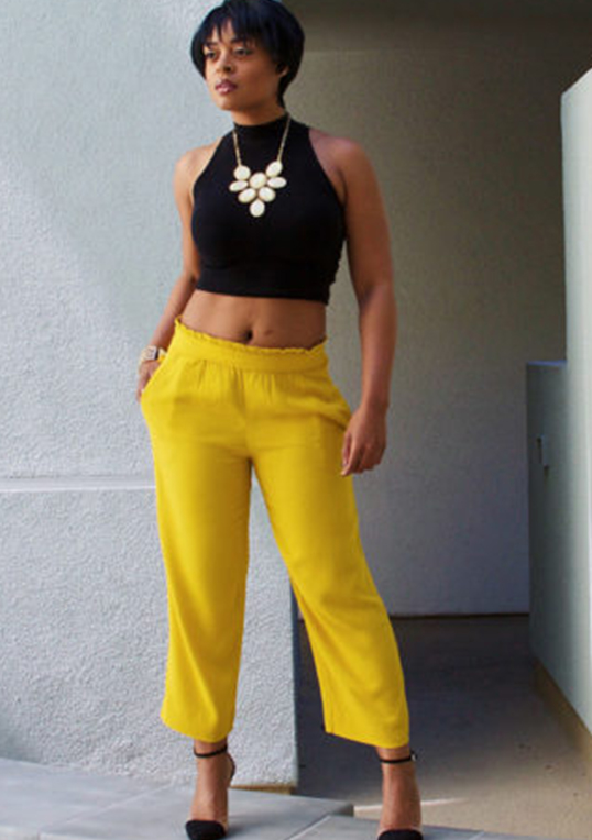 woman in black crop top and yellow trousers